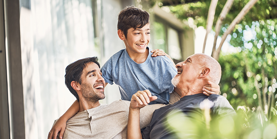 Happy multi-generation family talking at patio. Smiling males are spending leisure time together. They are having fun.